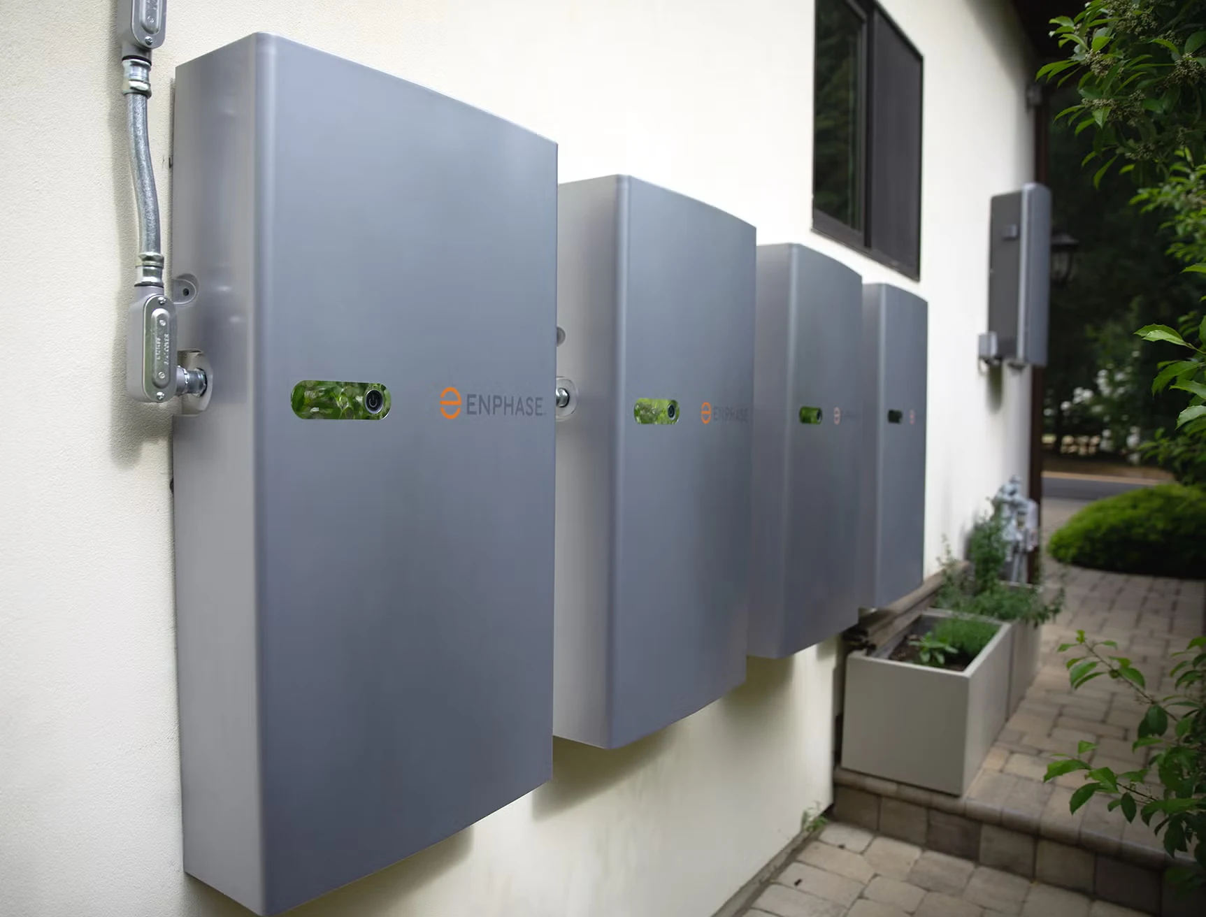 Enphase IQ Battery modules mounted on a wall, showing the compact stackable design with multiple units side by side