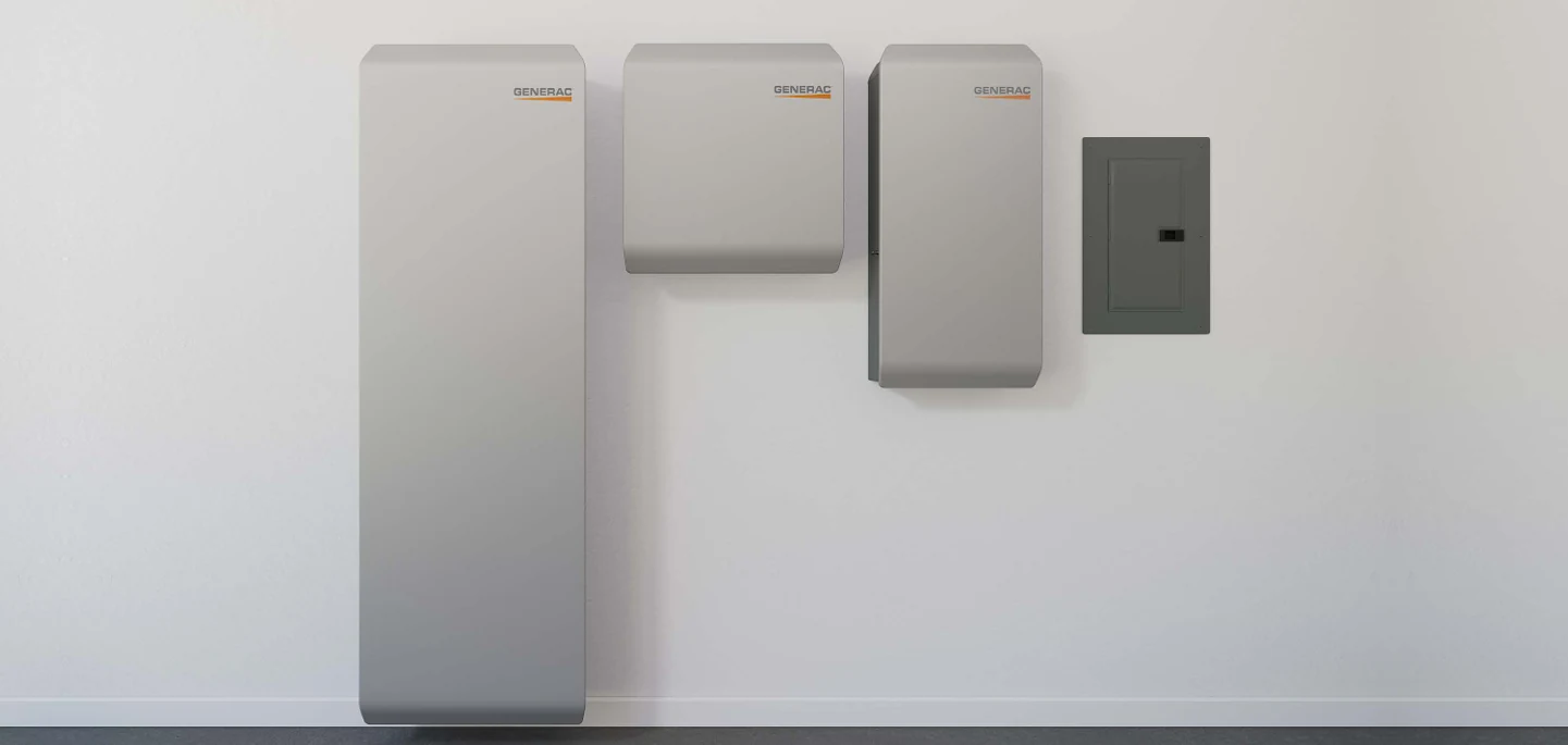 Generac PWRcell system mounted on a wall, showing the tall battery cabinet, PWRmanager unit, and electrical panel side by side